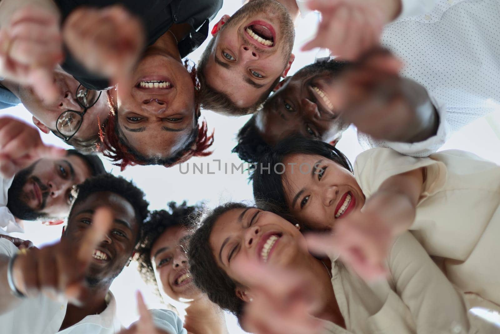 group of diverse young people standing in a circle and looking down