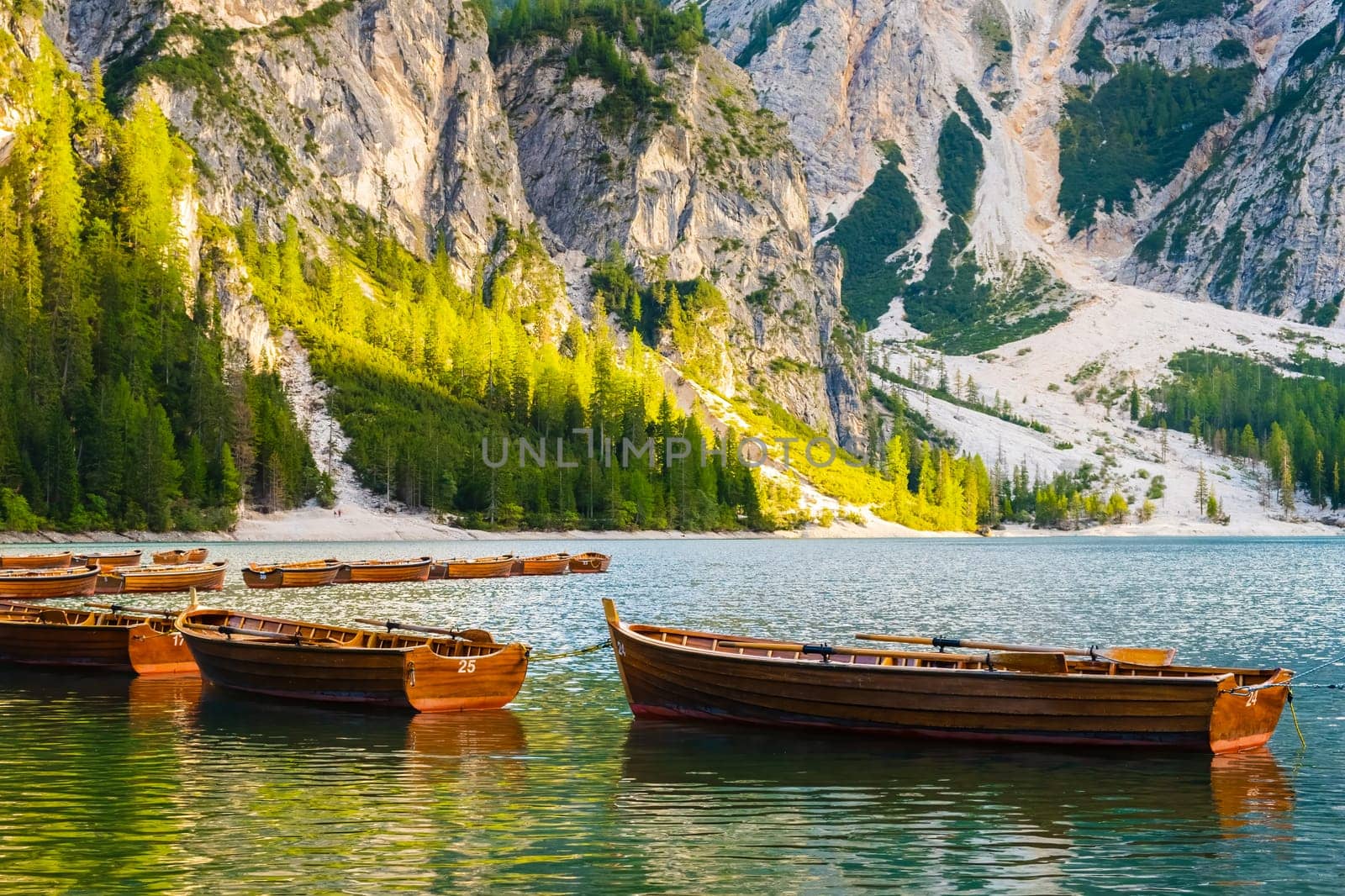 Wooden boats on the popular tourist lake Braies with amazing view of Dolomites Alps