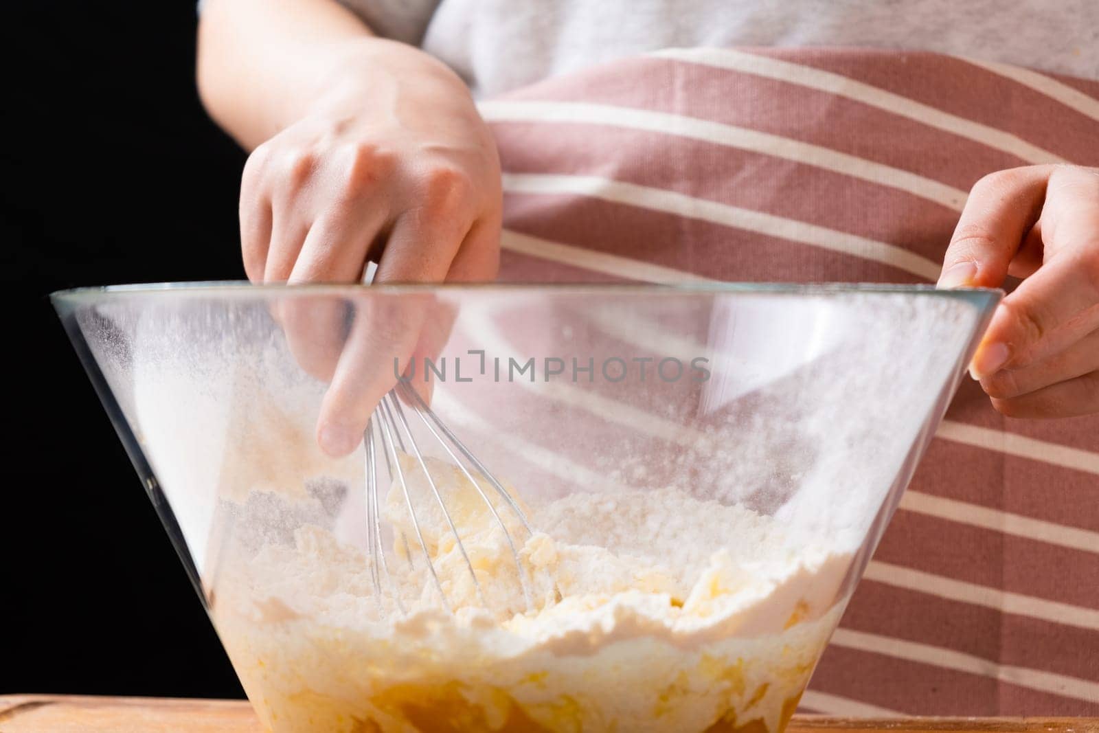 Close up of woman baker hands kneading the dough in the mixing bowl. Homemade pastry for cakes or cookies.