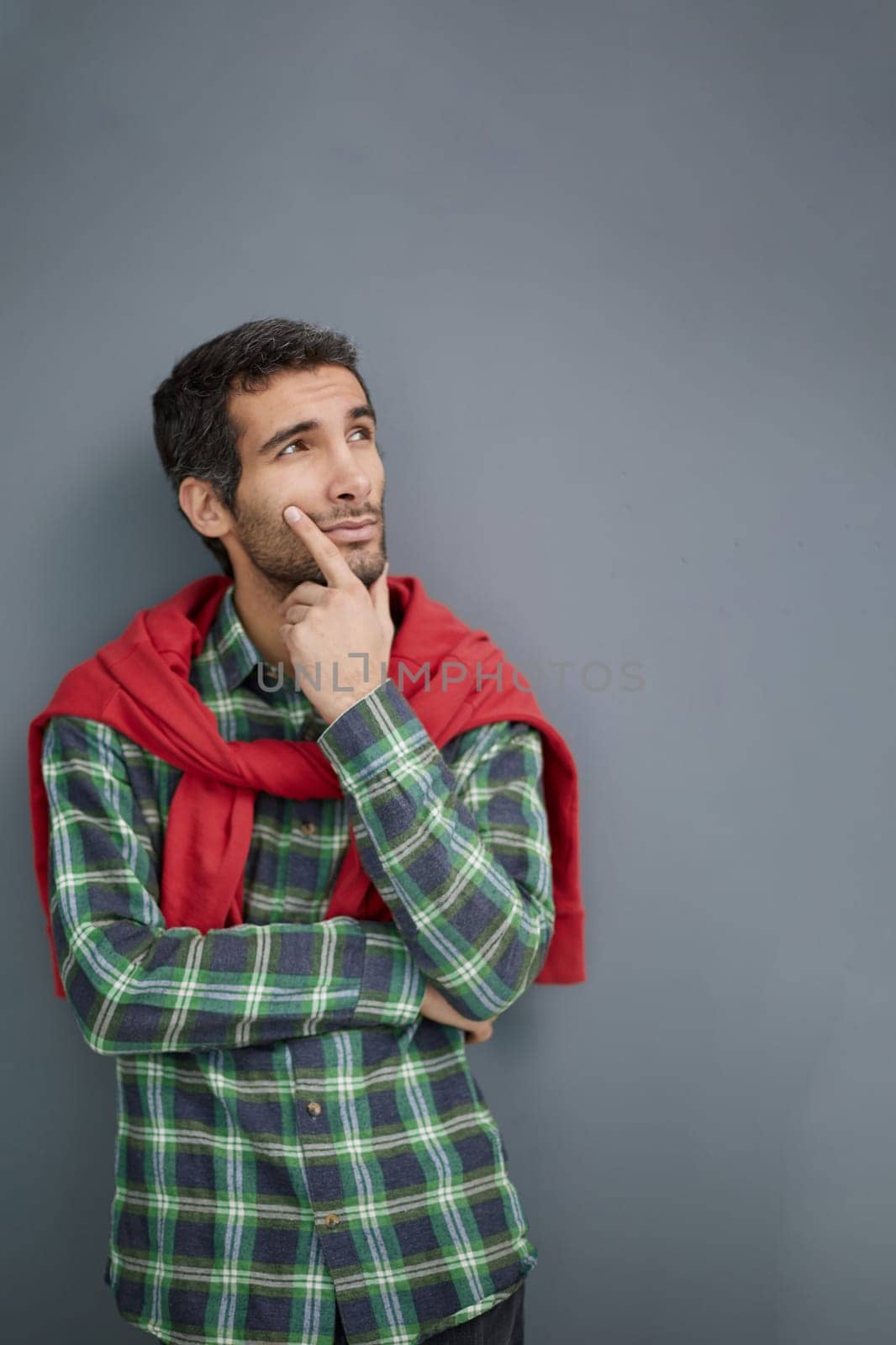 Handsome man in a plaid shirt on a gray background