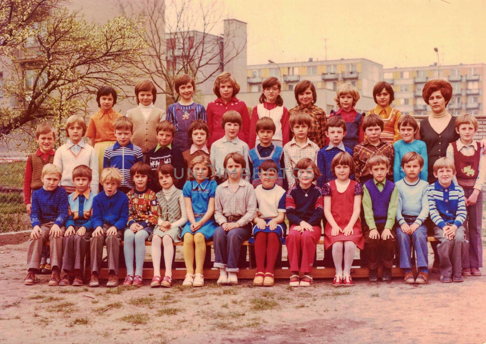 THE CZECHOSLOVAK SOCIALIST REPUBLIC - CIRCA 1980s: Retro photo shows small pupils and they female teacher (schoolmistress) pose for photograper outside. Color photo.