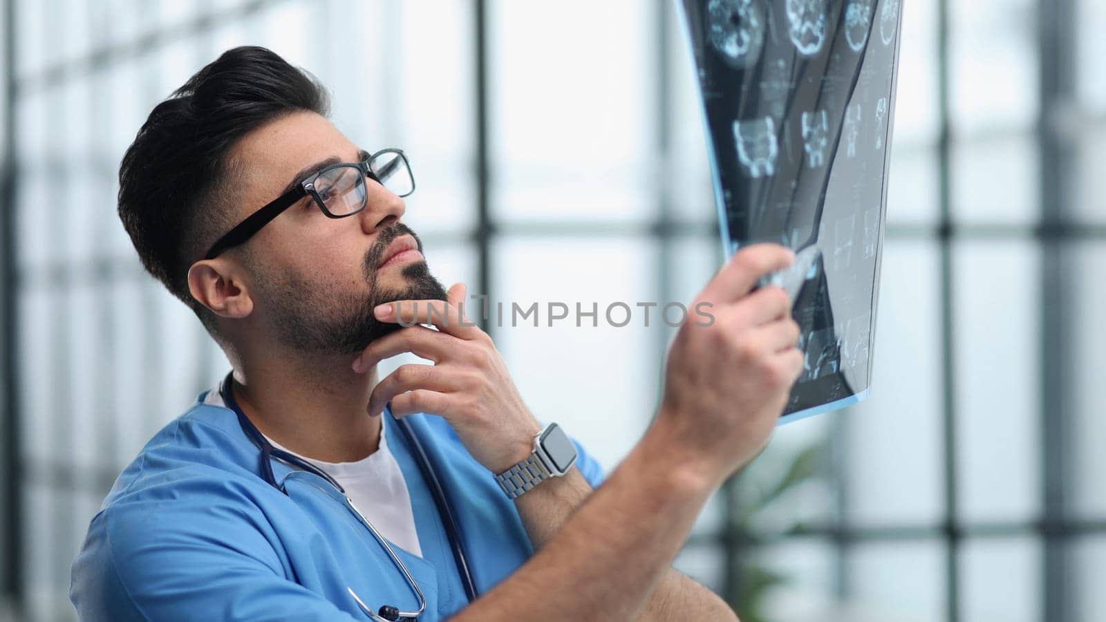 Confident doctor with x-ray picture in office