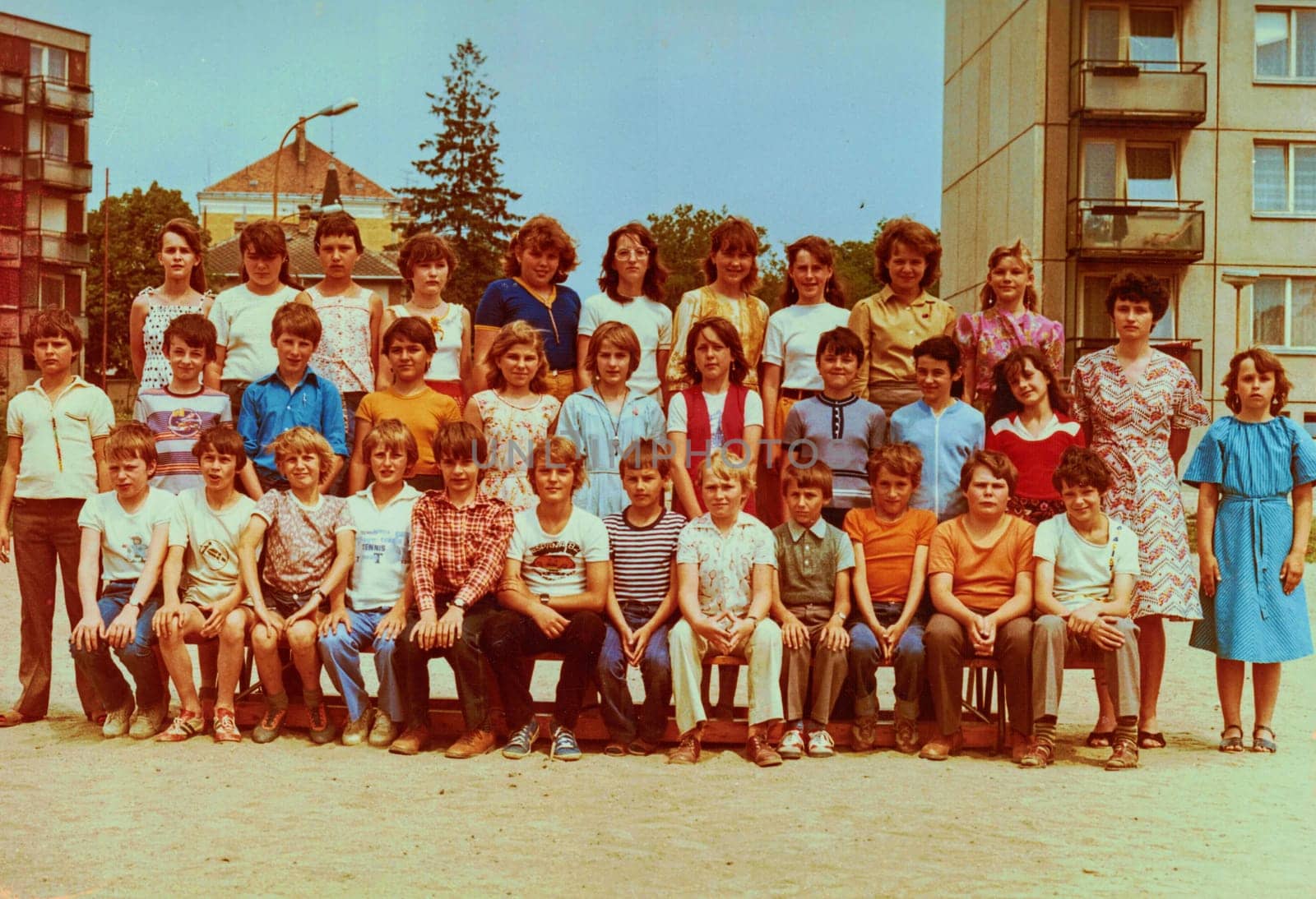 Retro photo of group of school pupils teenagers with their female teacher. by roman_nerud