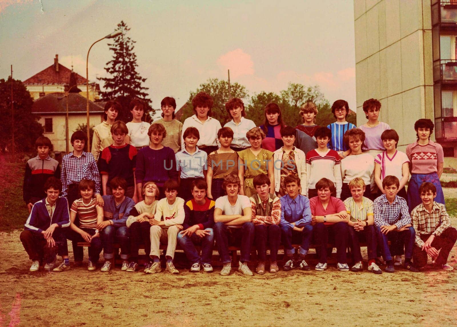 Retro photo of group of school pupils teenagers with their female teacher. Color photo by roman_nerud