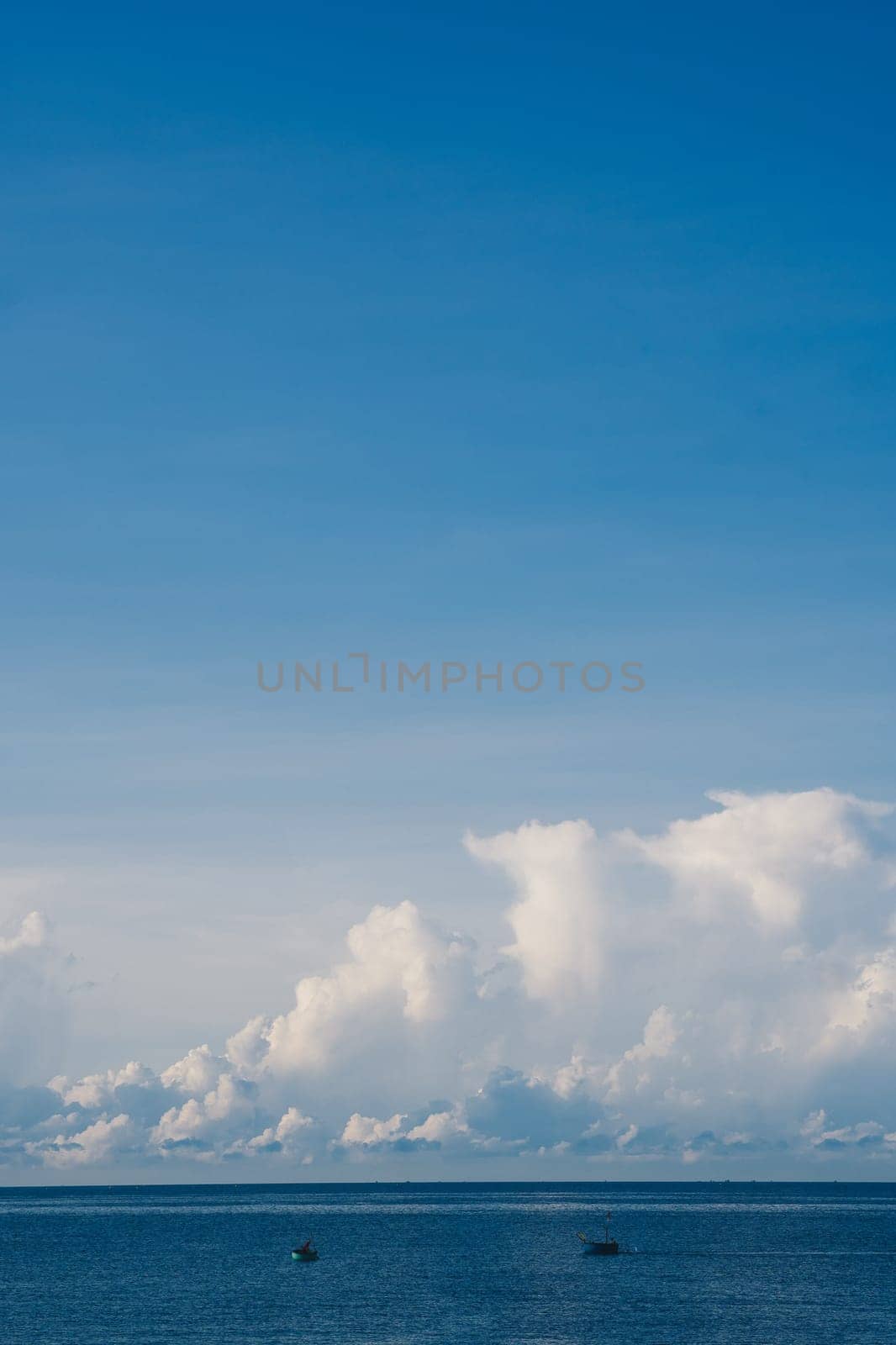 A blue sky with cumulus cumulus fluffy huge summer sun white clouds.