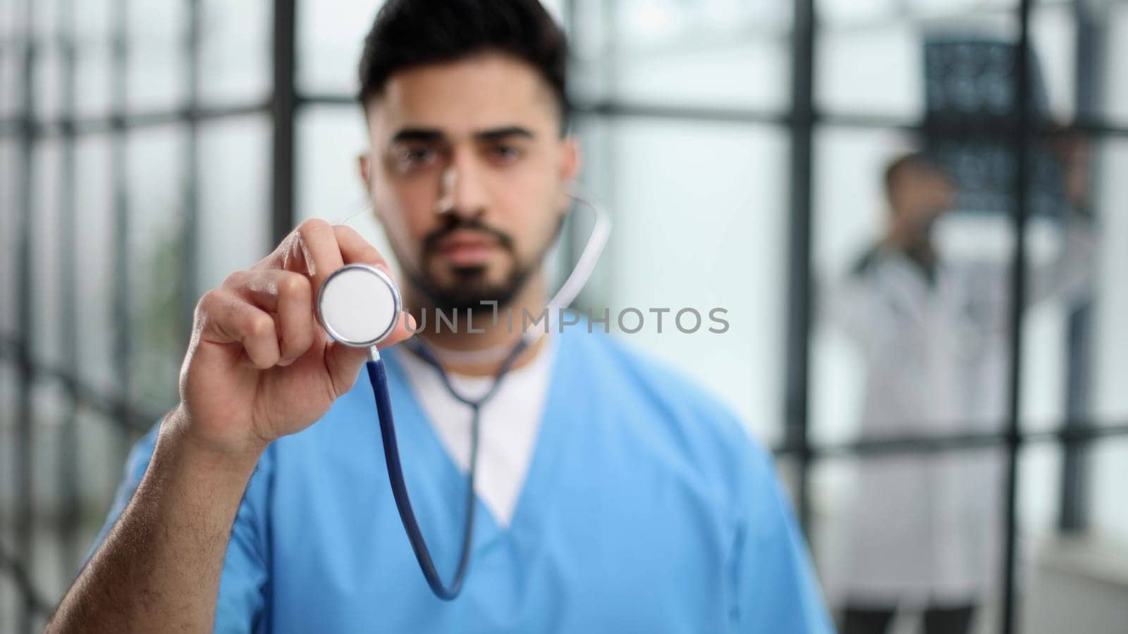 A futuristic doctor shows stethoscope and appear of advanced futuristic medicine symbols in holography.