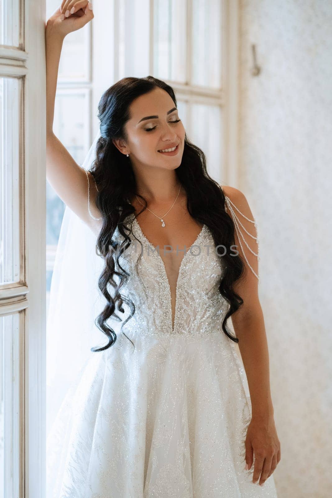 portrait of a bride in a white dress in a bright cafe with mirrors