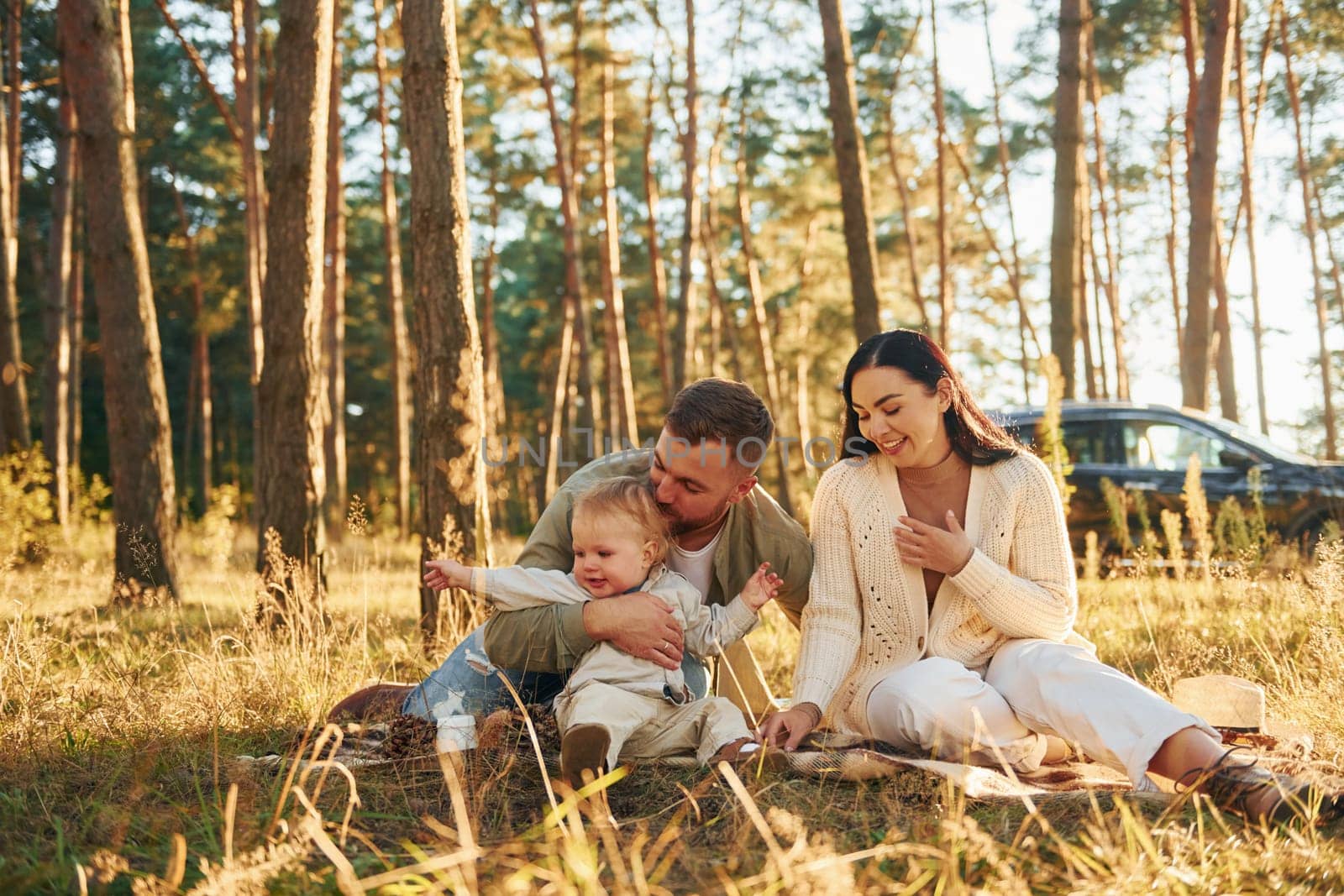 Positive emotions. Happy family of father, mother and little daughter is in the forest.
