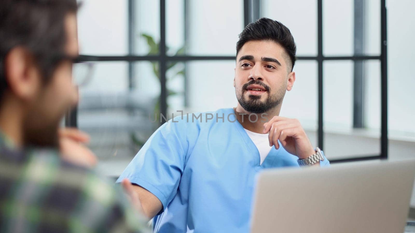 male doctor consulting patient filling form at consultation.