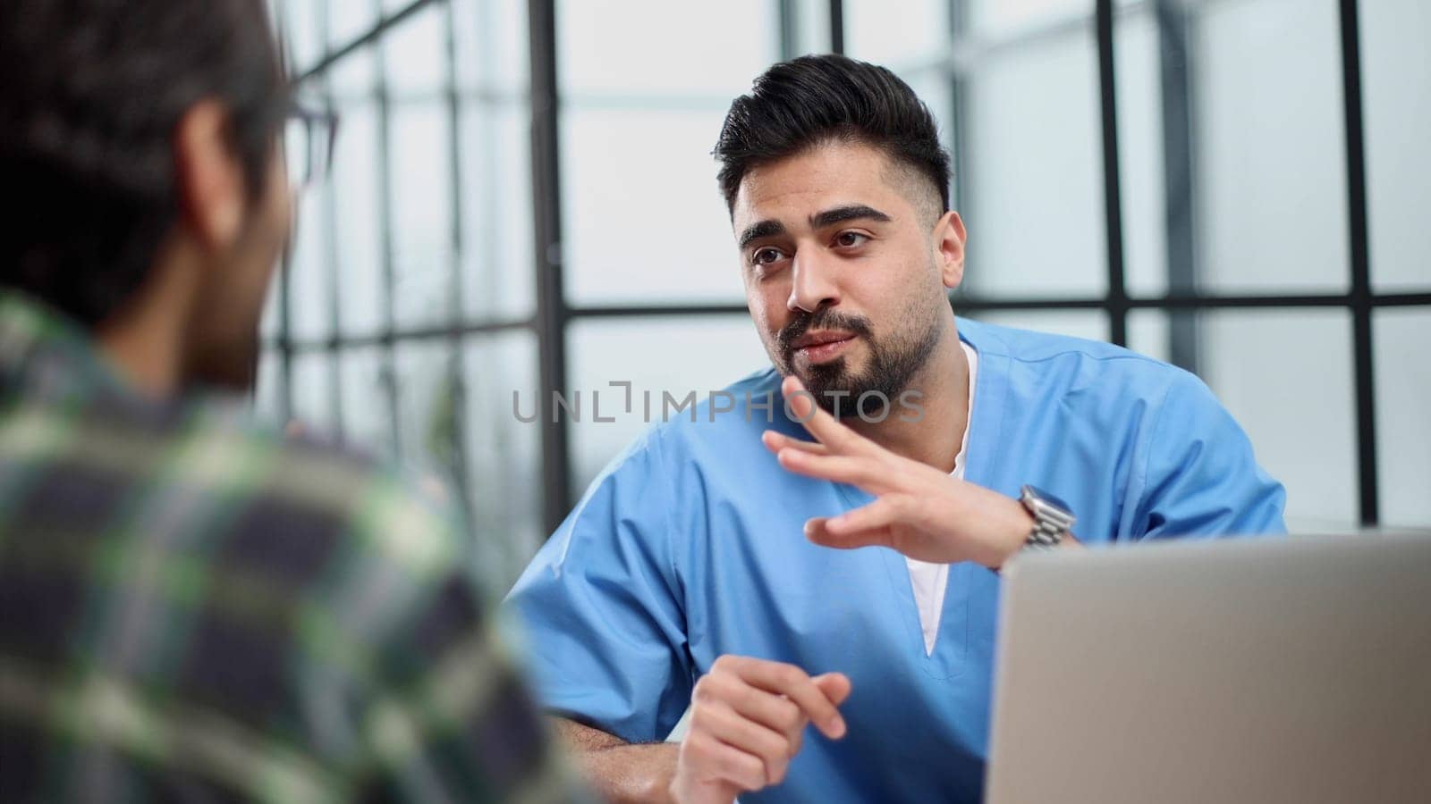 male doctor consulting patient filling form at consultation.