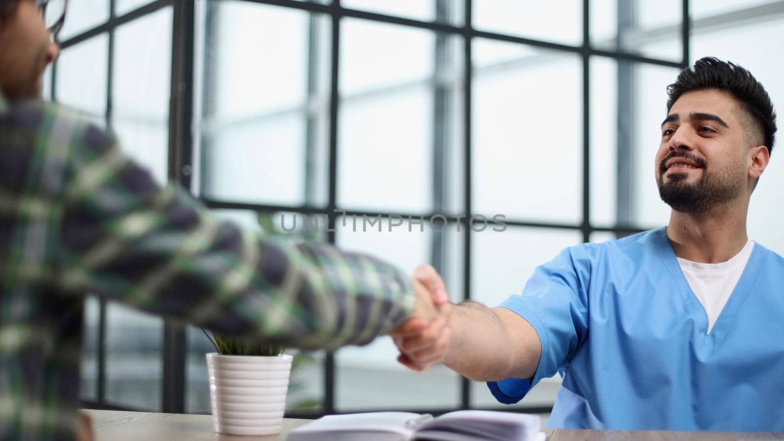 Handshake of the patient with the doctor in the hospital at the reception