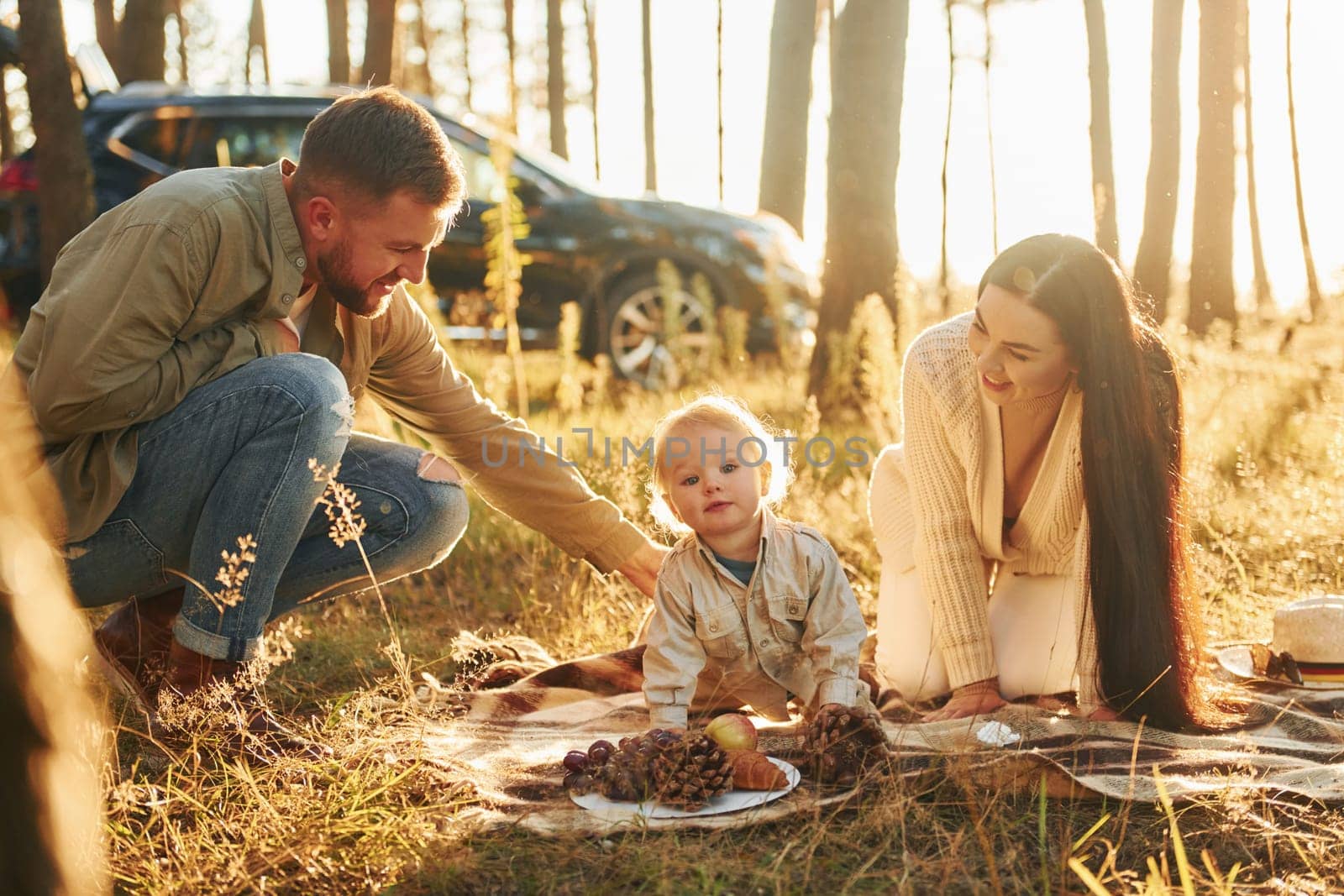 Playful mood. Happy family of father, mother and little daughter is in the forest.