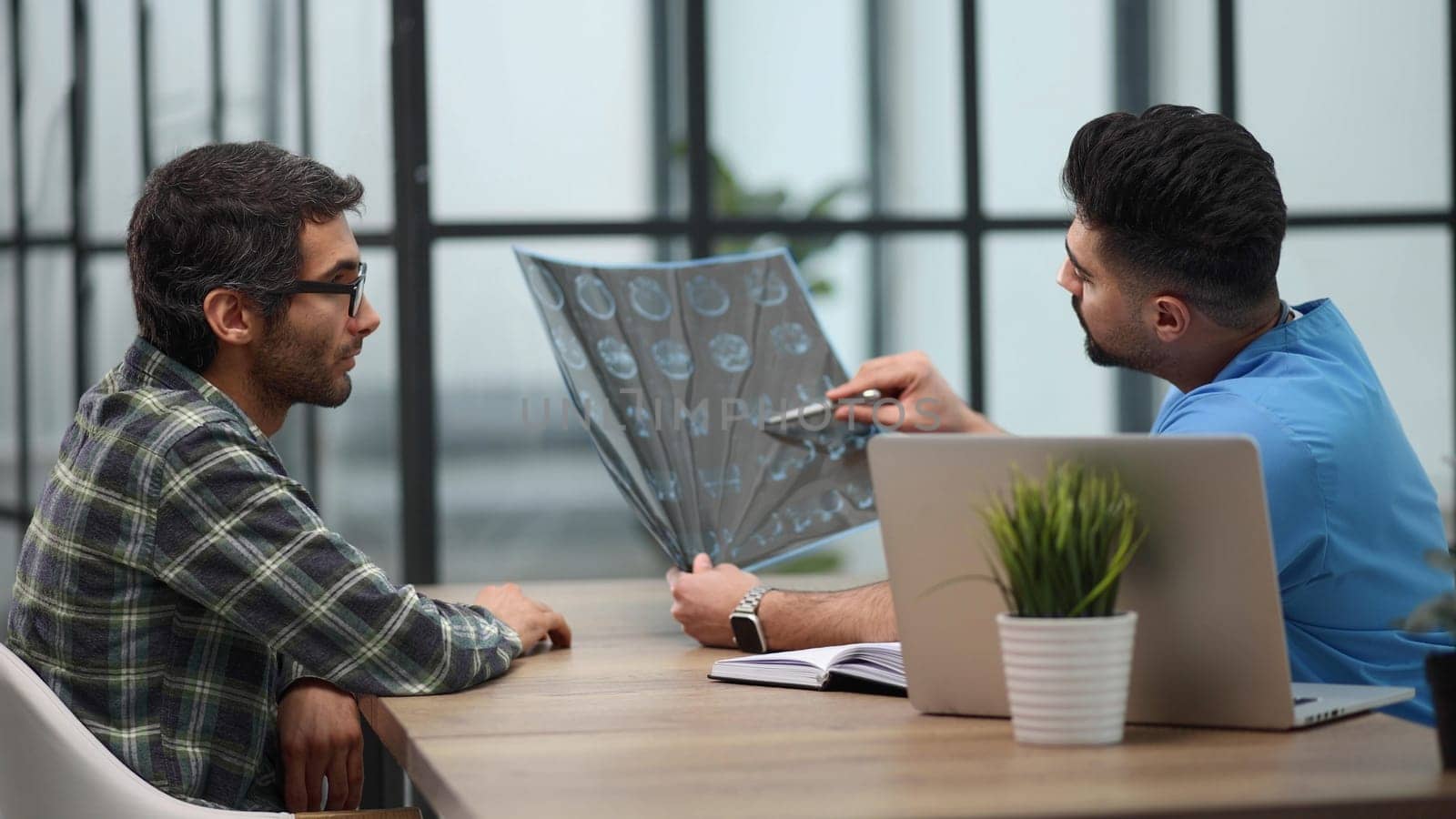 Pensive serious mature adult male physician consult shocked young man