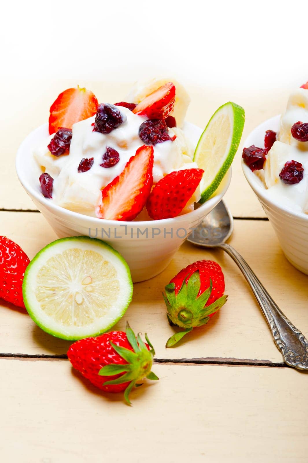 fruit and yogurt salad healthy breakfast over white wood table