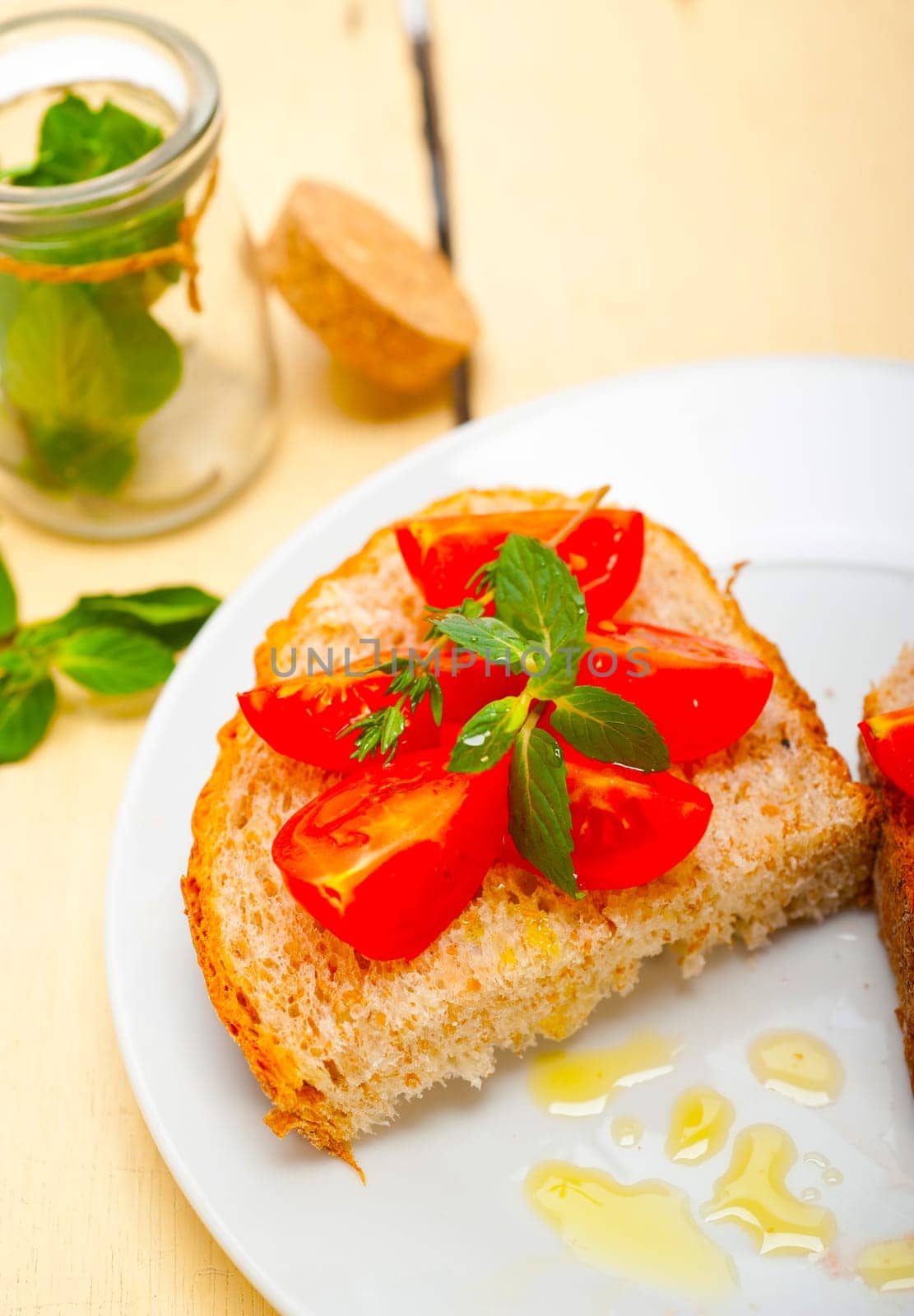 Italian tomato bruschetta with thyme and mint leaves 