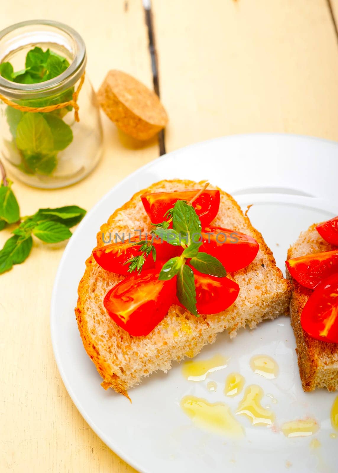 Italian tomato bruschetta with thyme and mint leaves 