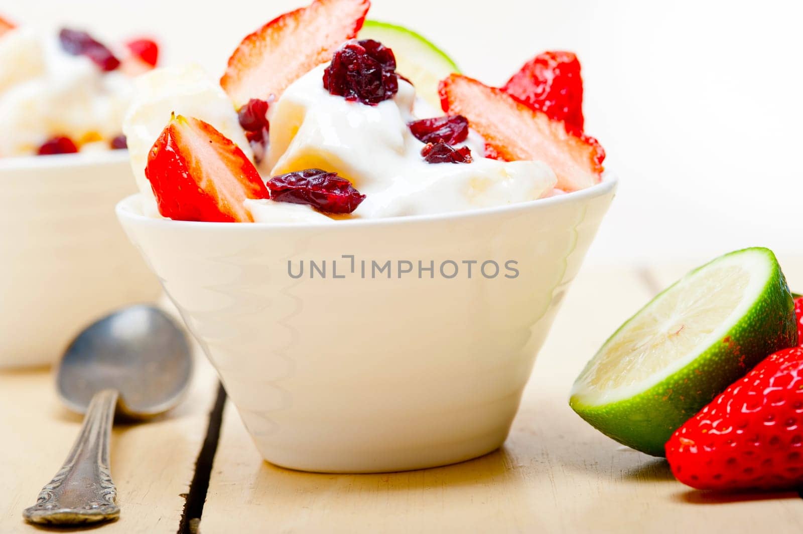 fruit and yogurt salad healthy breakfast over white wood table