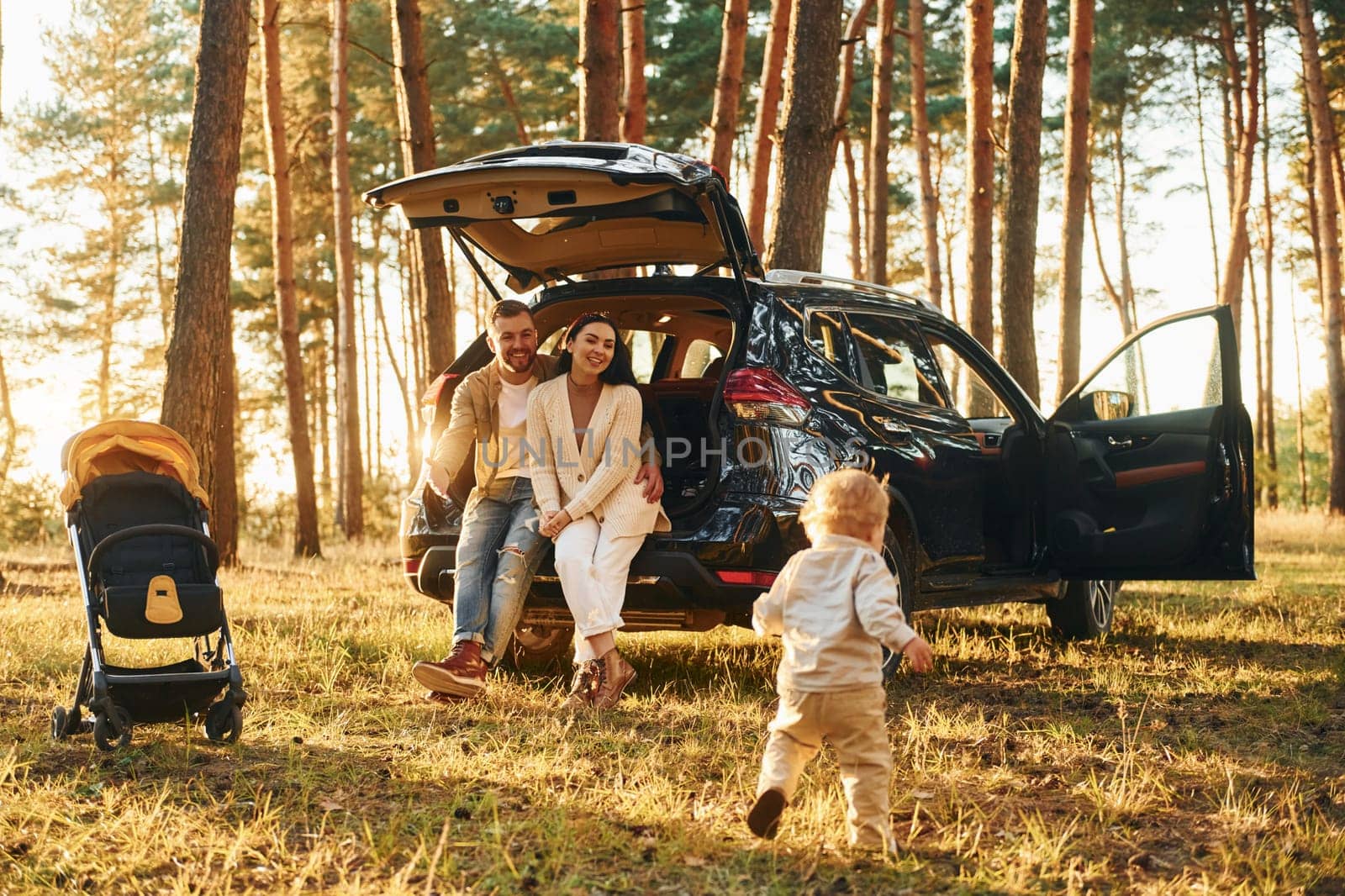 Joy and happiness. Family of father, mother and little daughter is in the forest by Standret
