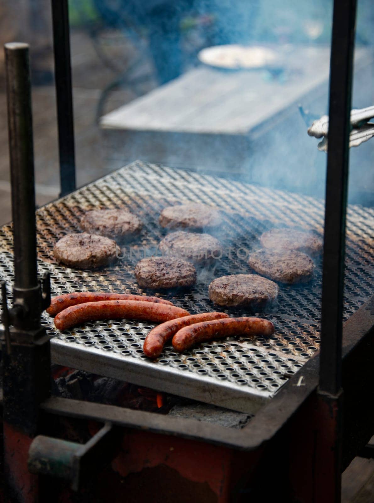 grilling meat on a wood fired barbecue with an open fire by compuinfoto