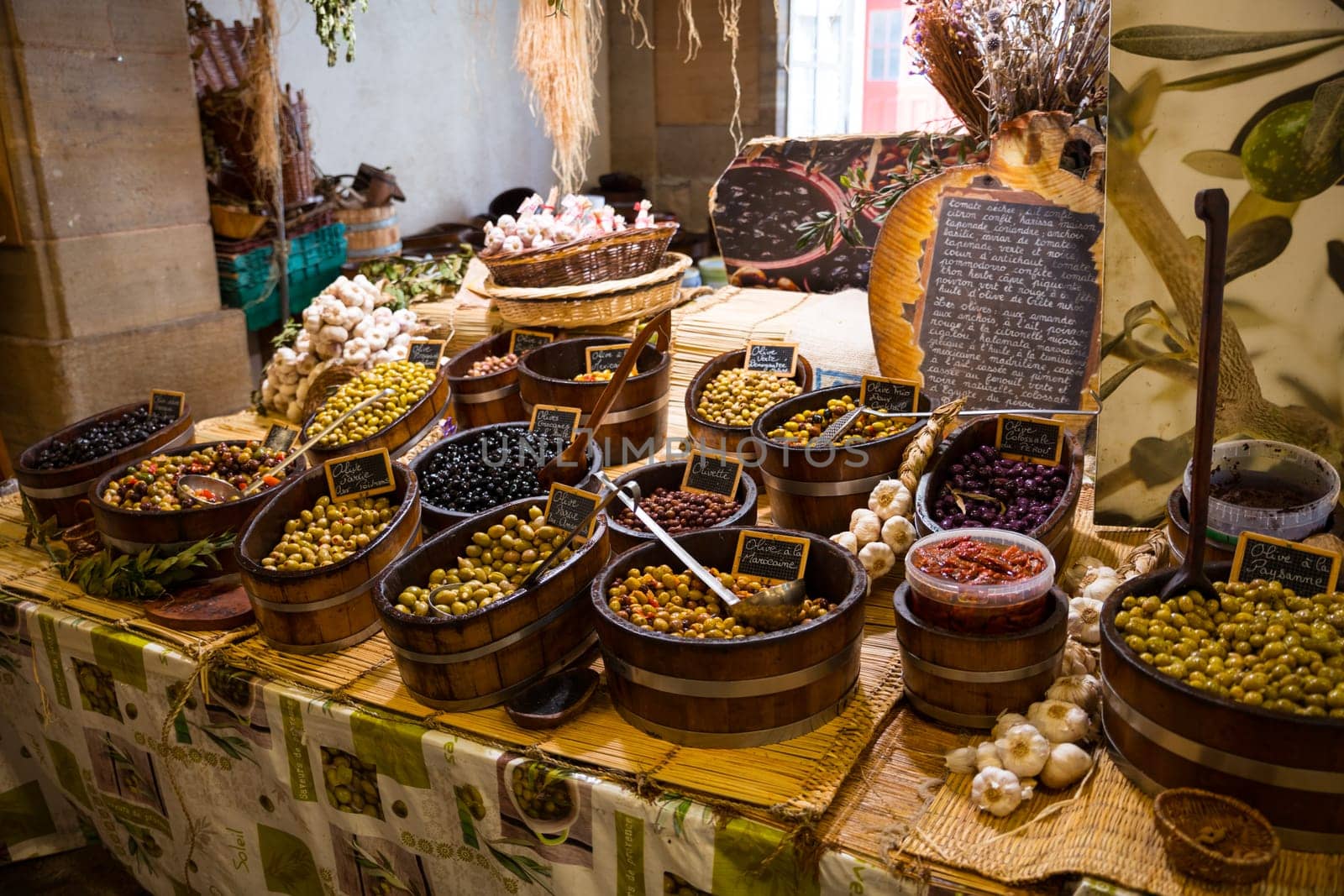 Uatun,france,24-08-2022: large wooden containers with olives with garlic and sauces in a shop in France