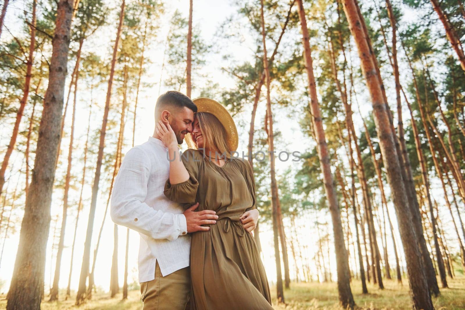 Weekend time spending. Happy couple is outdoors in the forest at daytime.