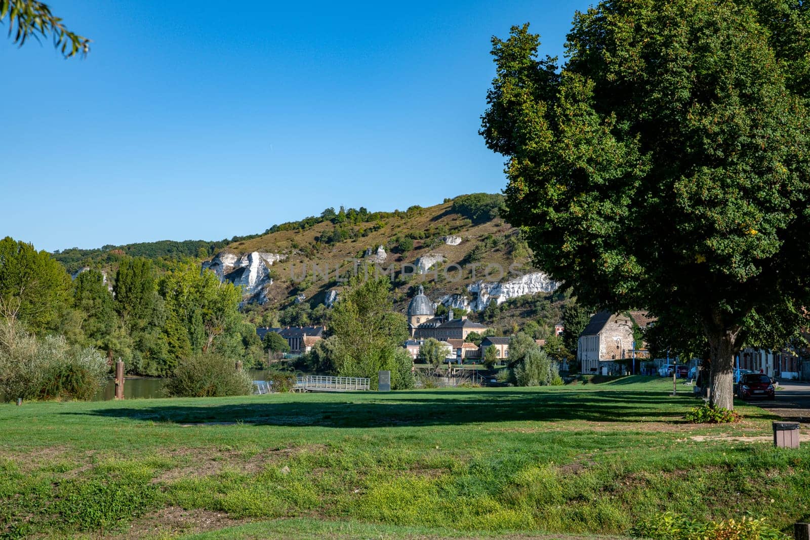 The village of les andelys in france with teh river seine and the rocks and nature on th background with houses and the church