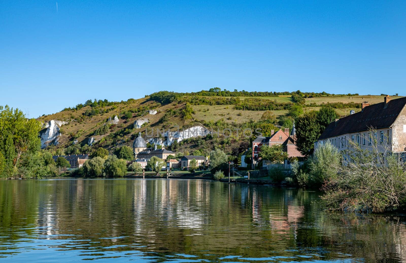 The village of les andelys in france with teh river seine and the rocks and nature on th background with houses and the church