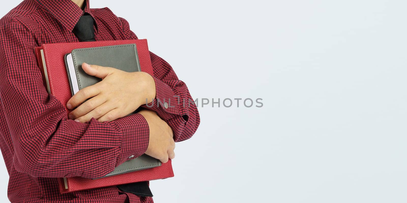 Pupil holding books in hands, isolated background. Education concept