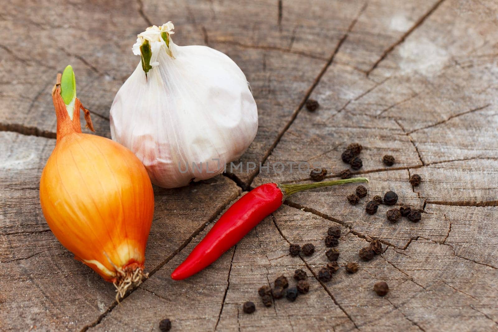 garlic and pepper on a wooden background close-up by EkaterinaPereslavtseva