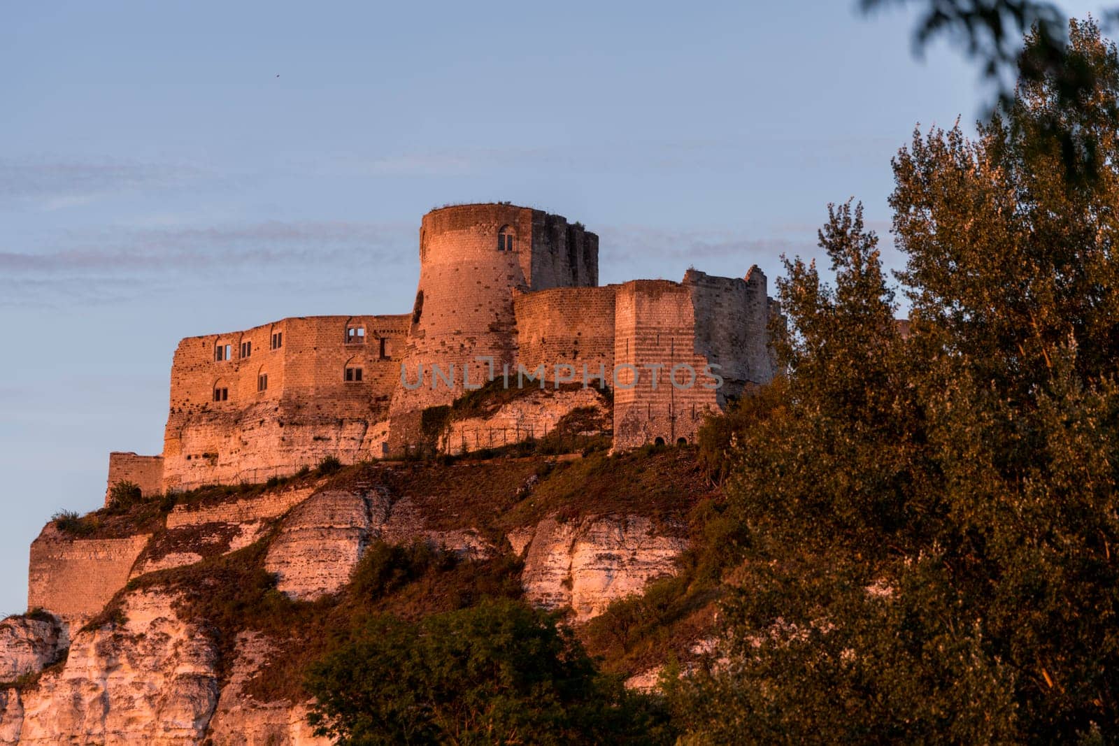 The Chateau de Beynac towers over the town of Beynac which clings to the rocks in a bend of the Dordogne river, France during golden hour