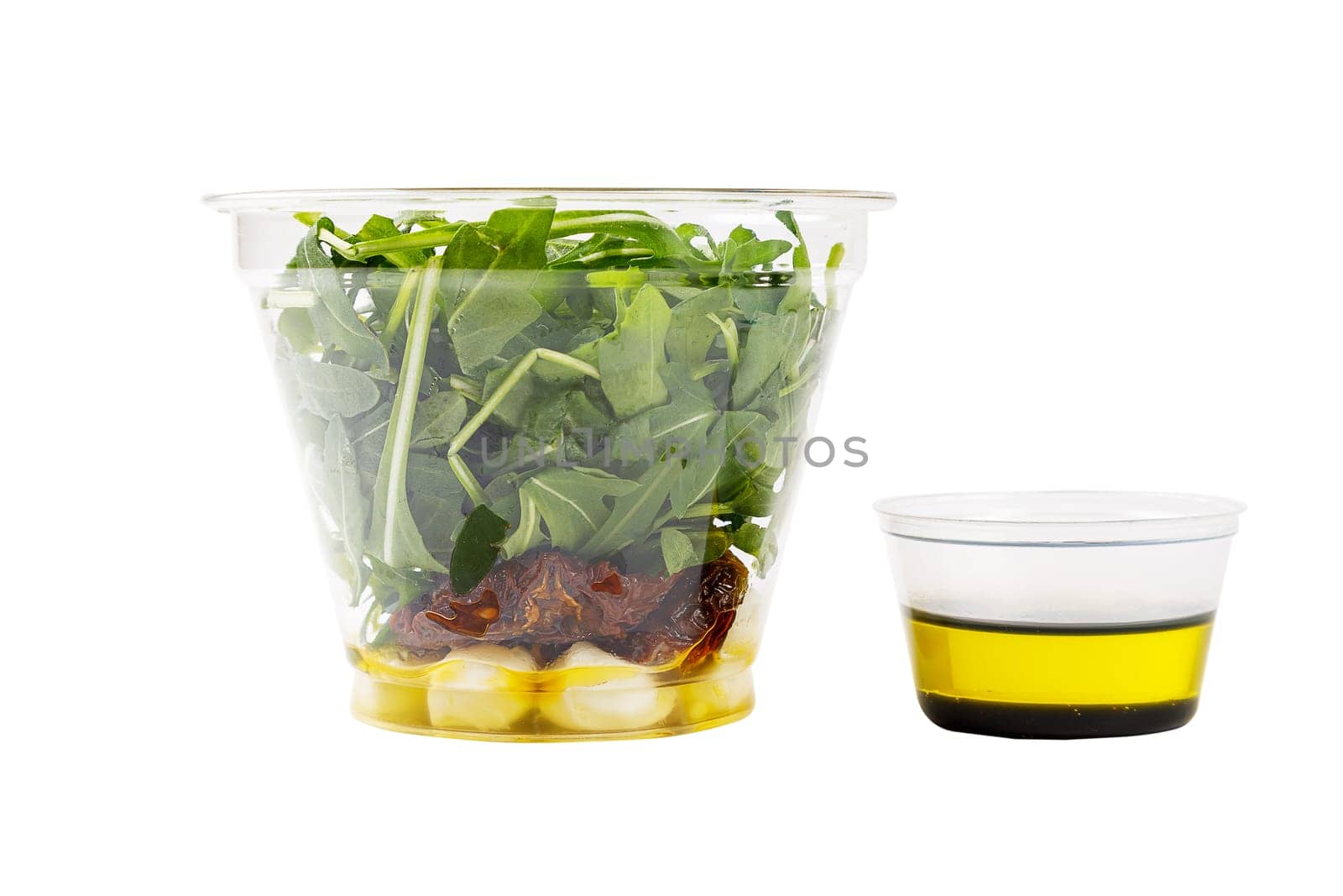 Fresh salad with arugula, mozzarella cheese, sun-dried tomato on a white background. Side view. Isolate.