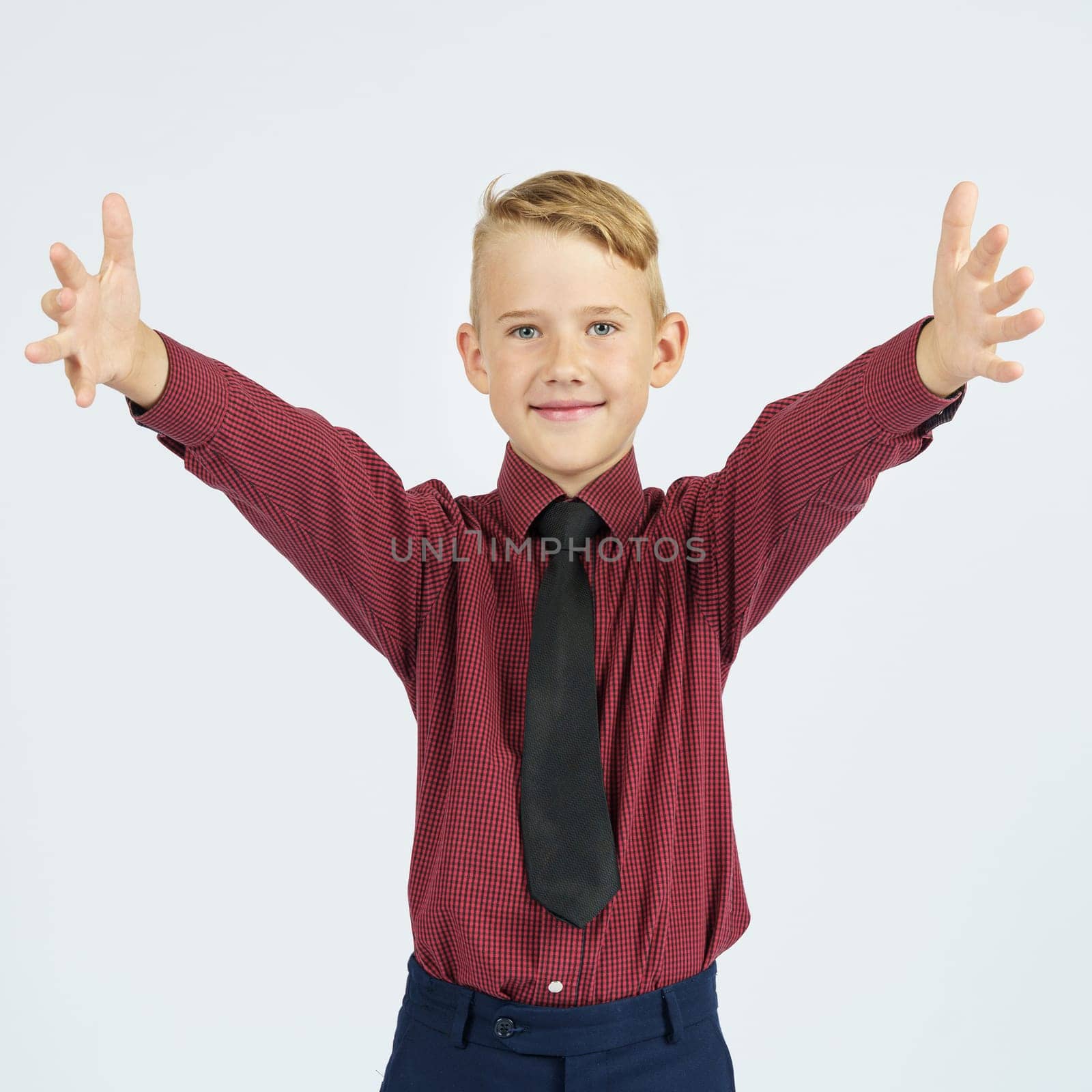 Portrait of a schoolboy with open arms who smiles. Education concept.