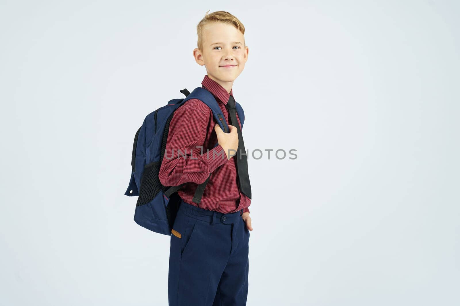 A schoolboy holds a school backpack, stands sideways, looks at the camera. by Sd28DimoN_1976