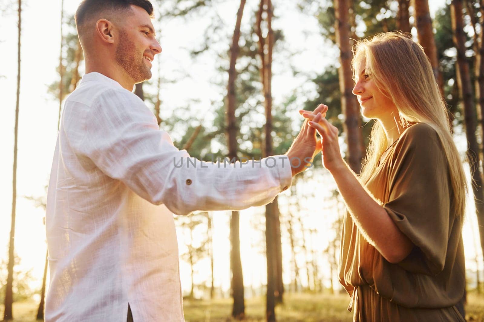 Cheerful people. Happy couple is outdoors in the forest at daytime.