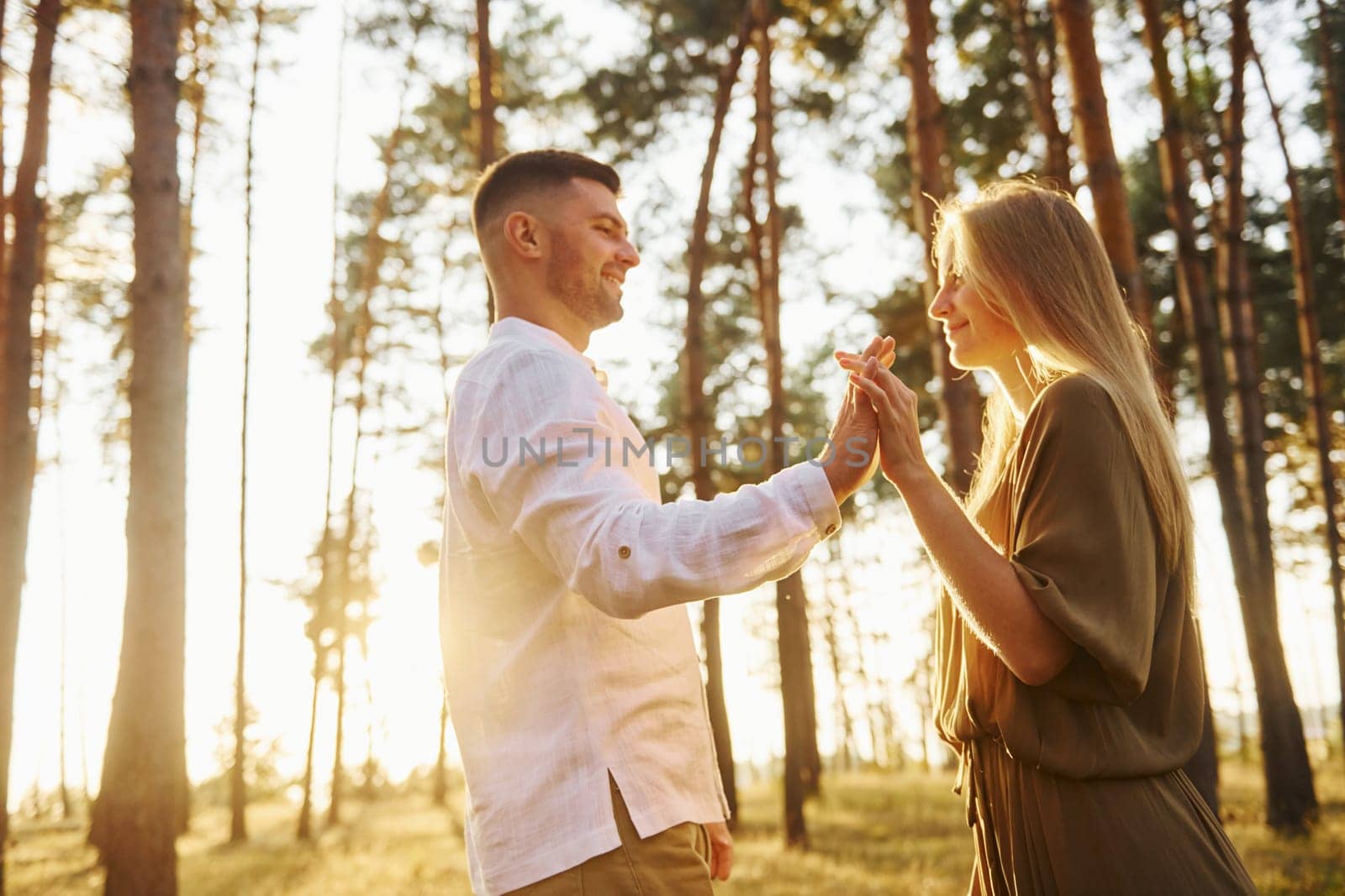 Cheerful people. Happy couple is outdoors in the forest at daytime.