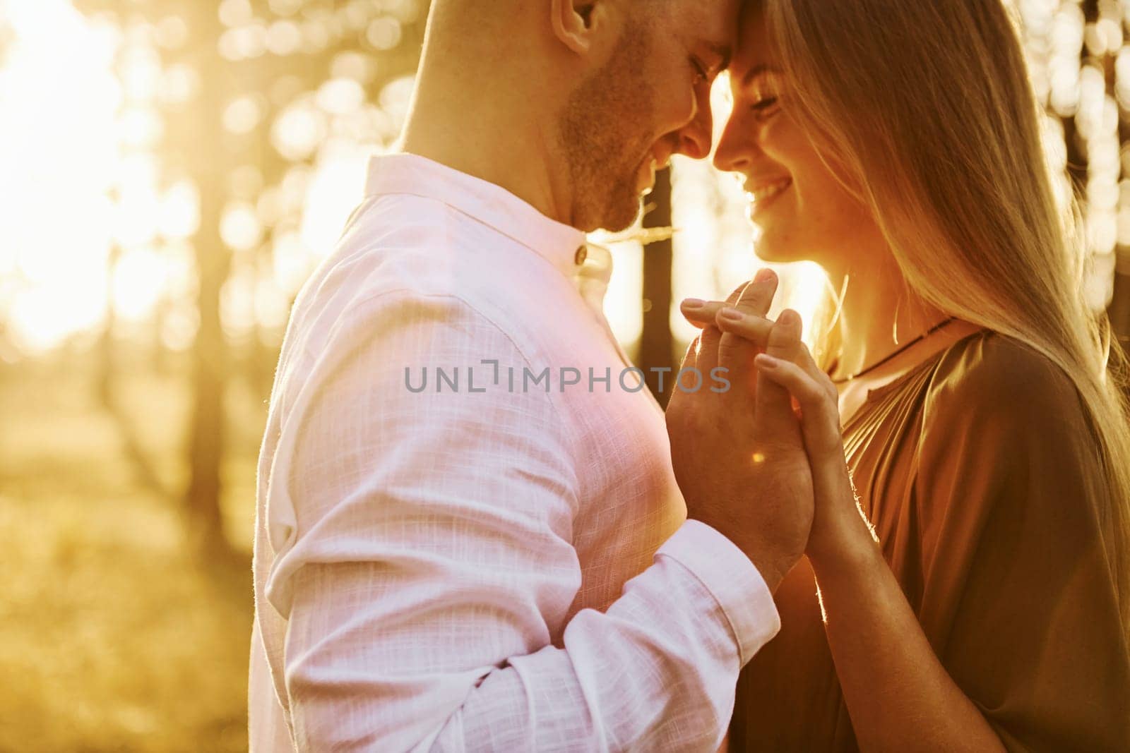 Cheerful people. Happy couple is outdoors in the forest at daytime.