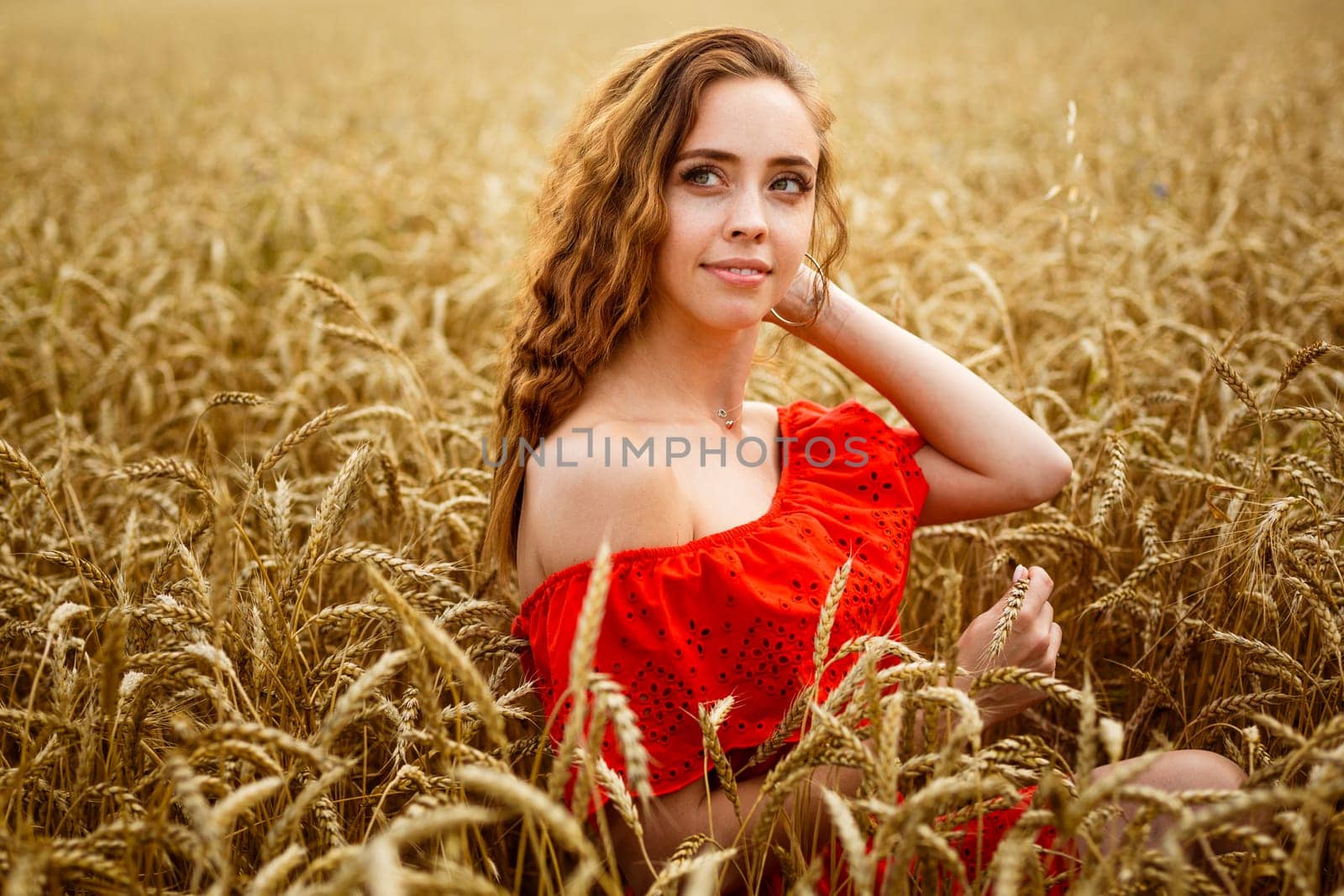 Redhead young woman in red dress on wheat field. Happy by EkaterinaPereslavtseva