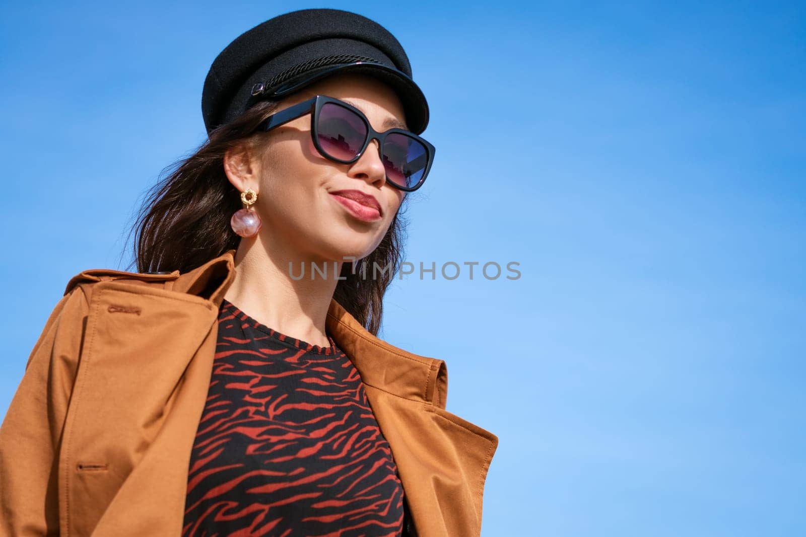 Female portrait of a young woman against a blue sky in sunglasses by EkaterinaPereslavtseva