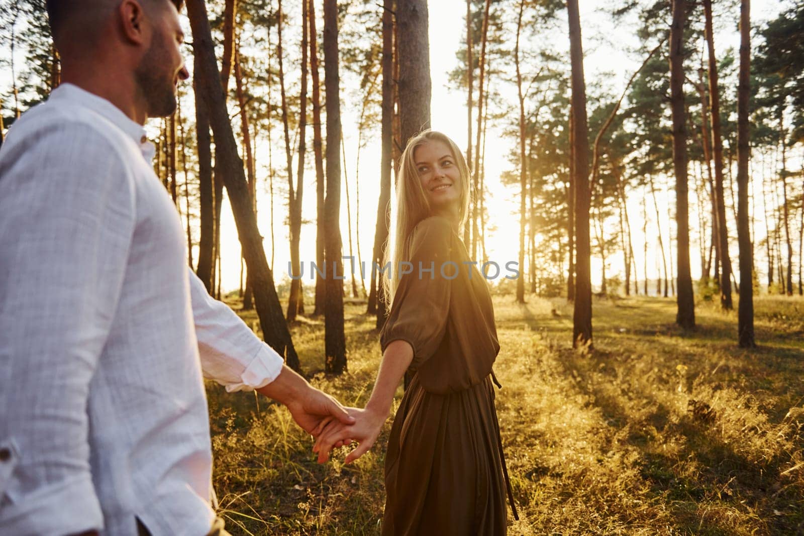 Non urban scene. Happy couple is outdoors in the forest at daytime.