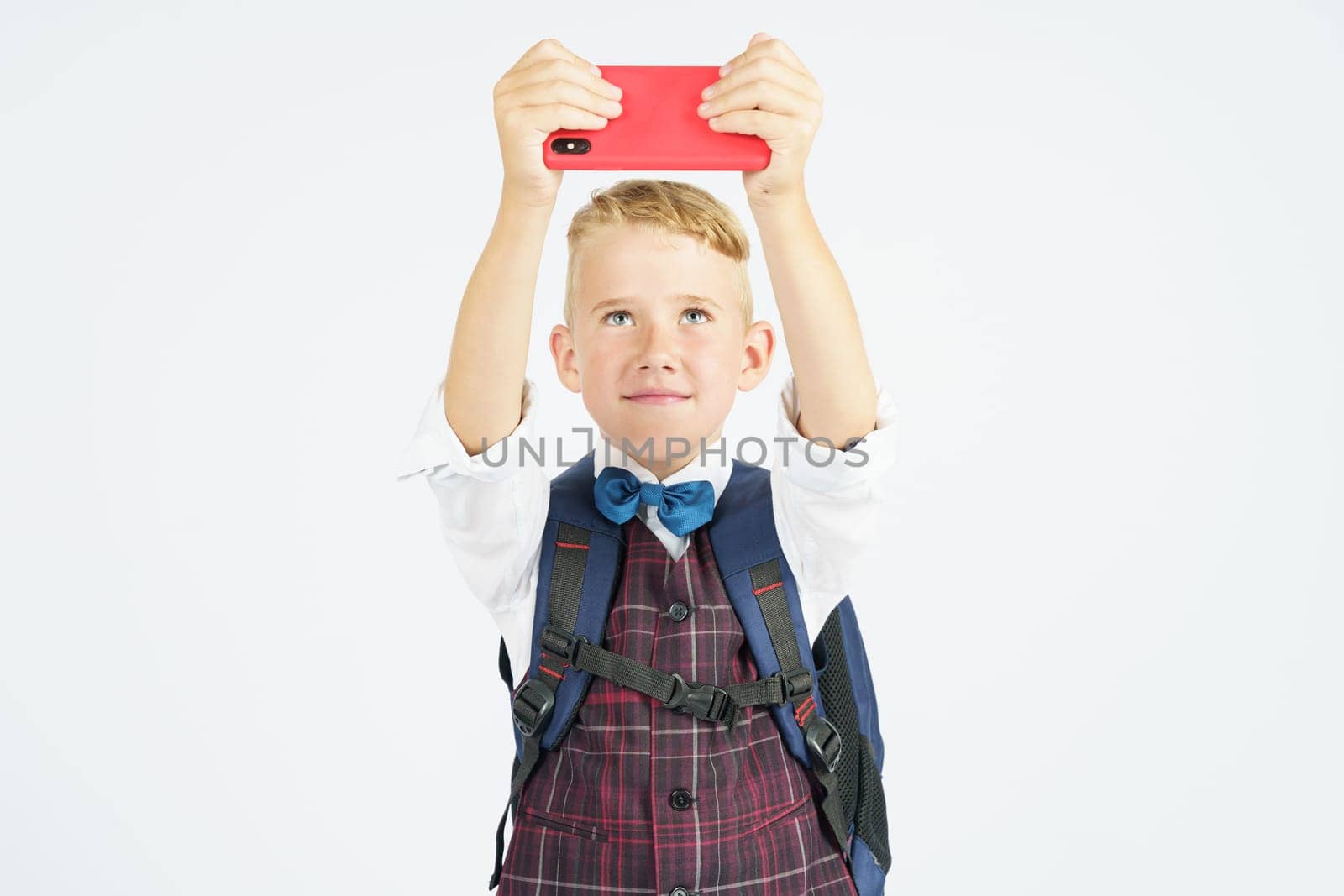 Portrait of a schoolboy taking a selfie on a mobile phone. Isolated background. by Sd28DimoN_1976