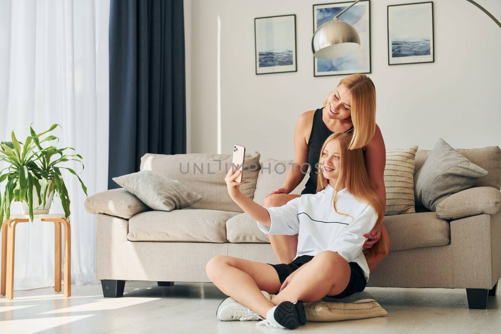 Making selfie. Female teenager with her mother is at home at daytime.