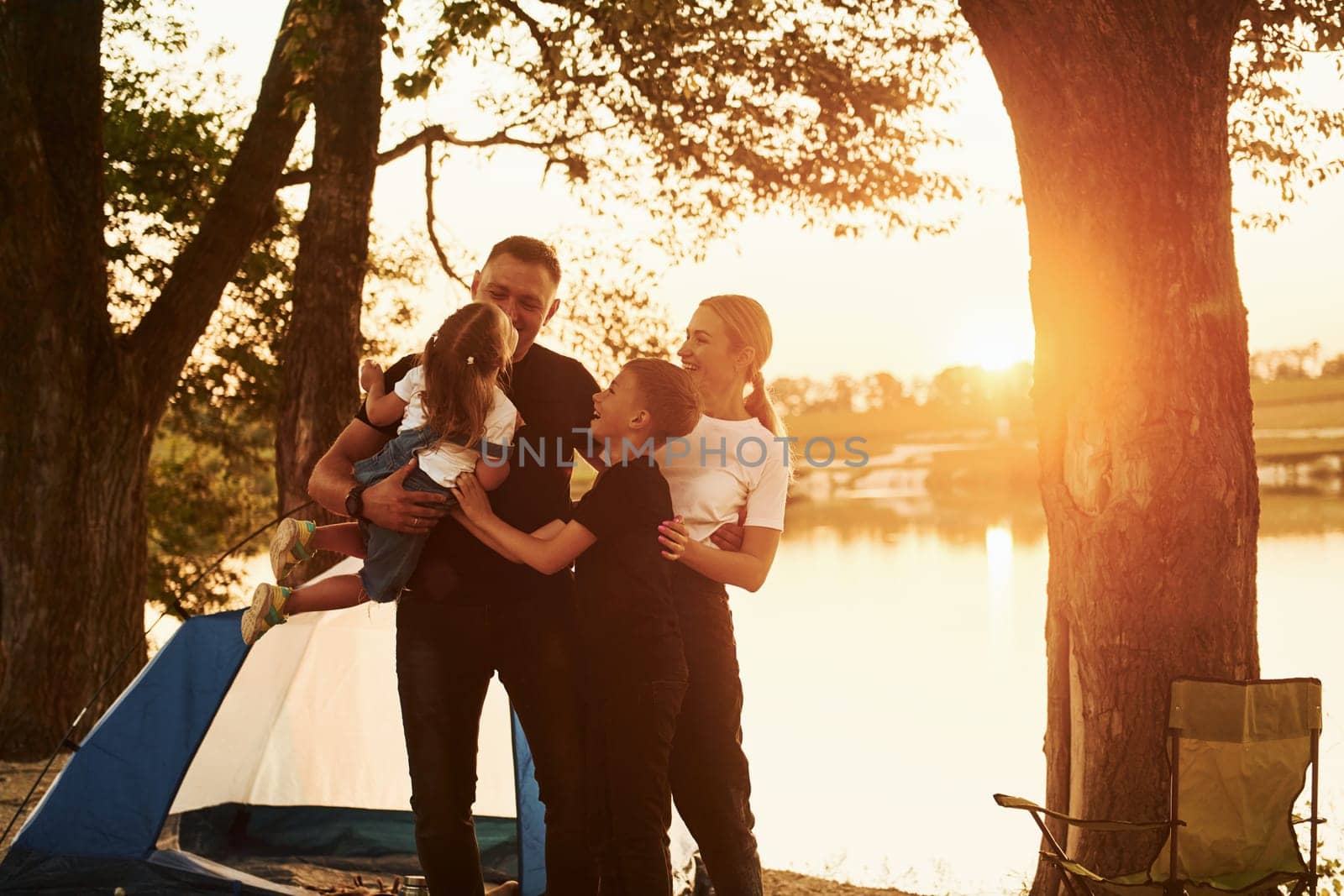 Active time spending. Family of mother, father and kids is on the camping.