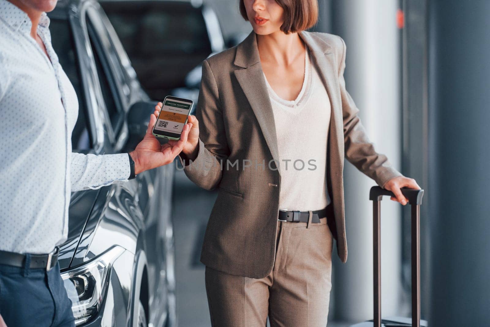 Using smartphone. Woman showing her vaccine passport to the man.