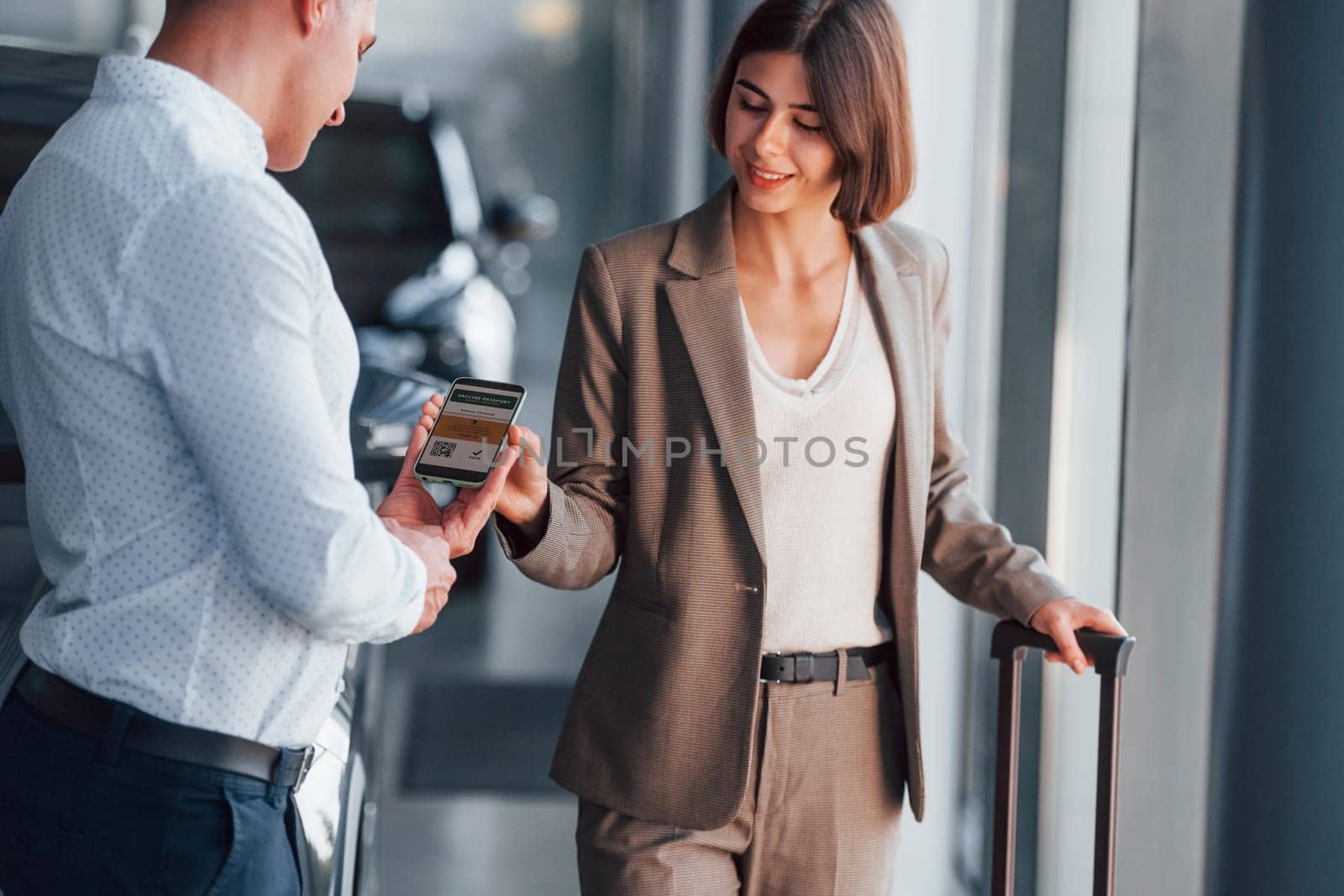 Modern technologies. Woman showing her vaccine passport by using smartphone to the man.