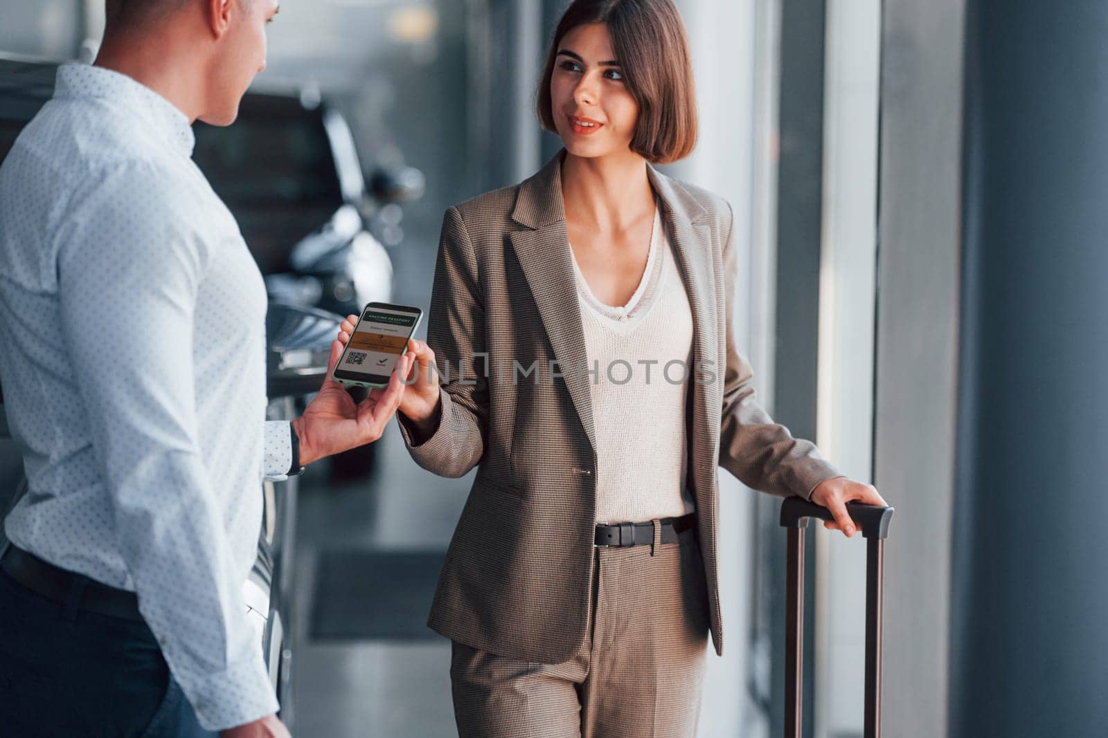 Modern technologies. Woman showing her vaccine passport by using smartphone to the man.
