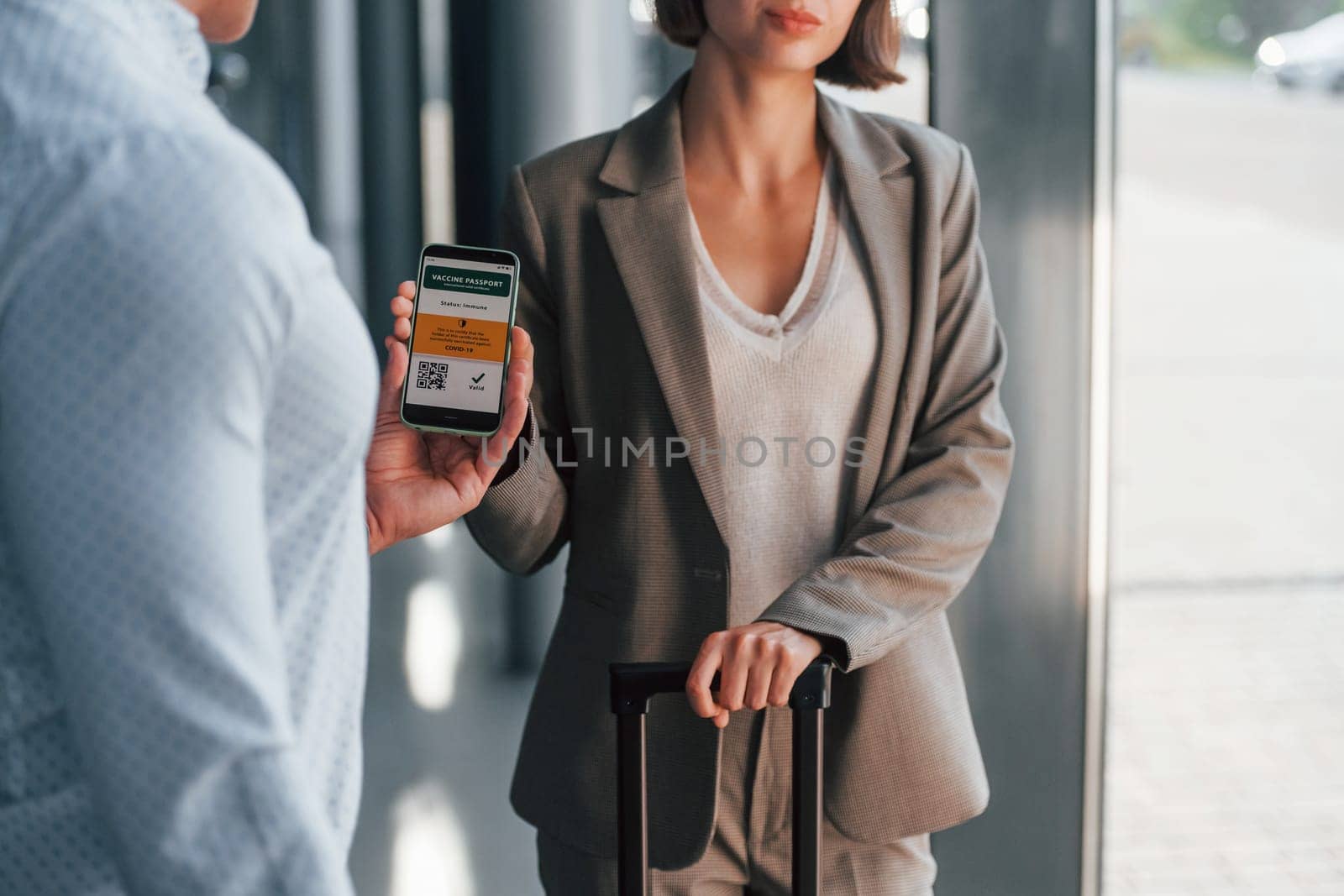 Modern technologies. Woman showing her vaccine passport by using smartphone to the man.