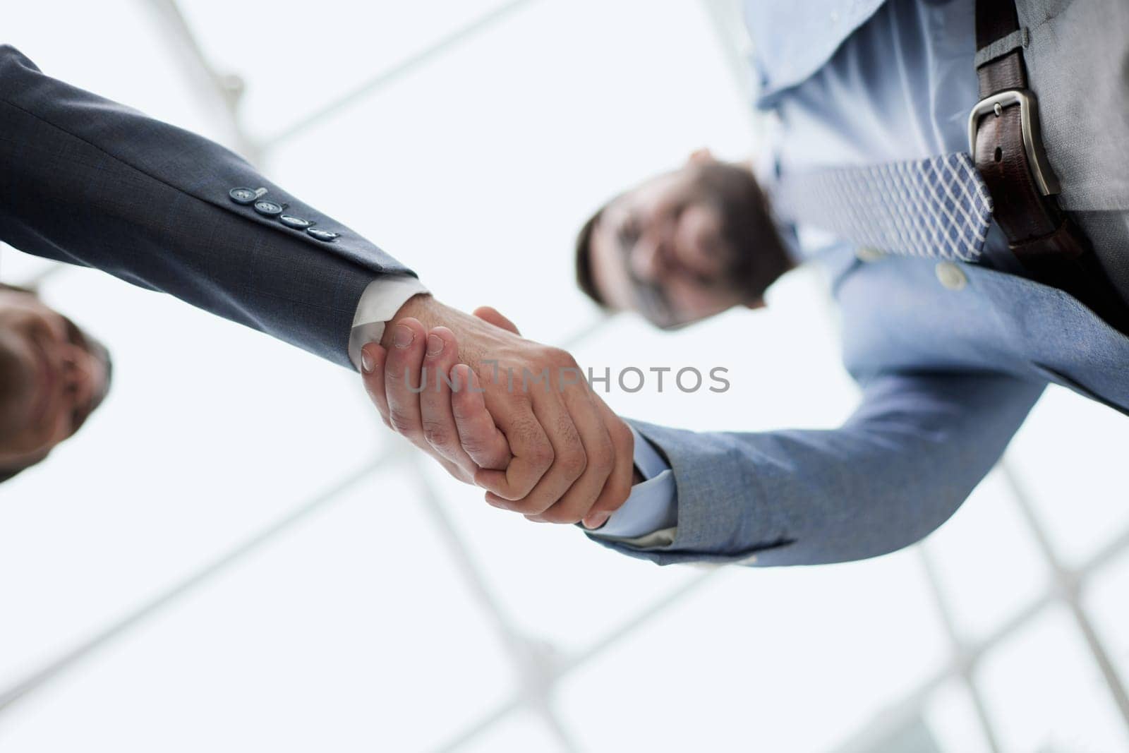 Business partners shaking hands in meeting hall