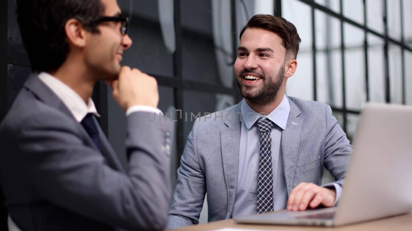 Young designer giving some new ideas about project to his partners in conference room