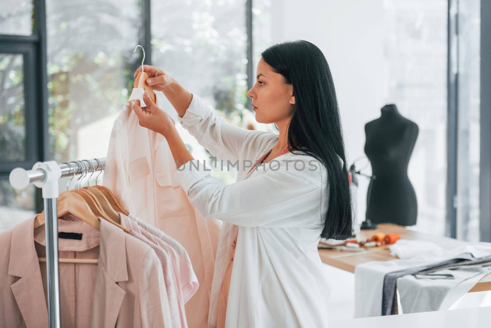 Taking clothes. Seamstress is in her office at daytime.