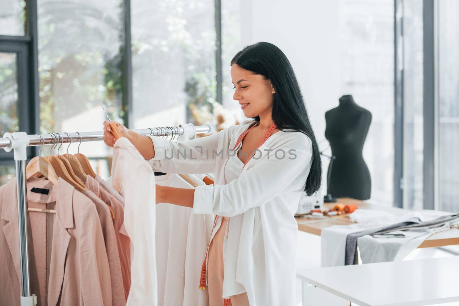 Taking clothes. Seamstress is in her office at daytime.